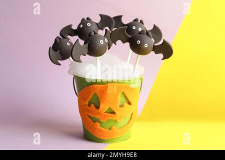 Köstlicher Kuchen in Fledermausform auf farbigem Hintergrund. Halloween-Leckerbissen Stockfoto