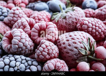 Mischung verschiedener gefrorener leckerer Beeren als Hintergrund, Nahaufnahme Stockfoto