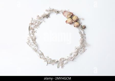 Getrocknete Blumen in Form eines Kranzes auf weißem Hintergrund, flach liegend mit Platz für Text. Herbstästhetik Stockfoto