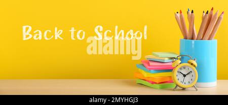 Text Back to School und anderes Schreibwaren auf gelbem Hintergrund. Bannerdesign Stockfoto