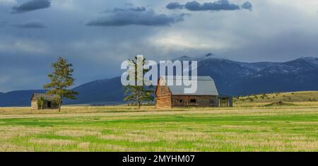 Panoramablick auf eine alte Scheune und Hütte unter dem Mount Baldy in der Nähe von townsend, montana Stockfoto