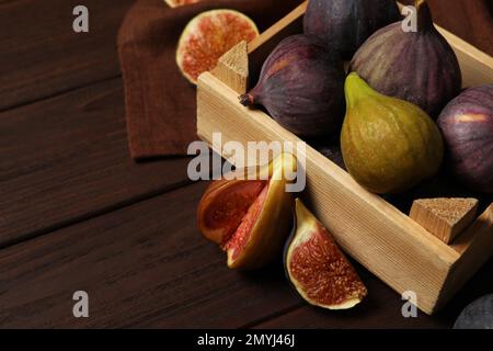 Leckere rohe Feigen in einer Kiste auf einem Holztisch, Nahaufnahme Stockfoto