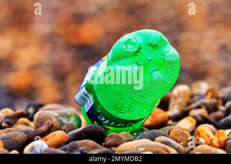 Grüne Plastikflasche liegt am Kieselstrand, Plastikabfall, Normandie, Frankreich, Europa Stockfoto