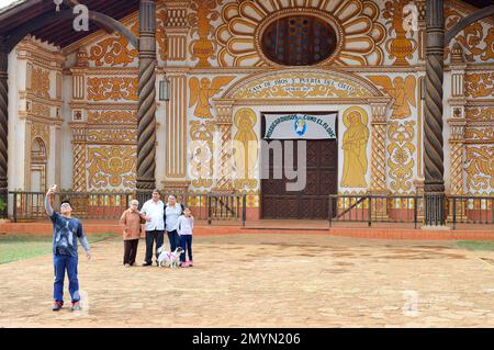 Familie macht ein Foto vor der bemalten Fassade der Kathedrale Inmaculada, Jesuitenreduktion der Chiquitos, UNESCO-Weltkulturerbe, Konz Stockfoto