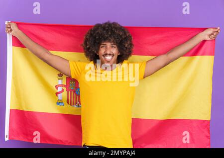 Glücklicher afrikaner, der eine spanische Flagge hisst Stockfoto