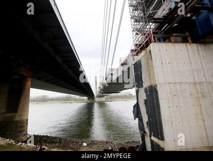 Duisburg, Deutschland. 01. Februar 2023. Die neue A40-Brücke (r) in der Nähe von Duisburg wird mit dem letzten 30-Meter-Abschnitt zusammengeführt; die verfallene alte Brücke befindet sich auf der linken Seite. Die Autobahn A40 verbindet das Ruhrgebiet mit dem Niederrhein und den Niederlanden. Die Neuenkamp-Rheinbrücke wurde 1970 gebaut, erreicht aber heute die Belastbarkeitsgrenzen. (An dpa-Korr: 'Nur noch 30 Zentimeter übrig: Die neue Duisburger Rheinbrücke kommt zusammen') Kredit: Roland Weihrauch/dpa/Alamy Live News Stockfoto