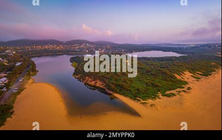 Sonnenaufgang mit Wolken, Nebel und Dunst über der Lagune in Wamberal an der Central Coast, NSW, Australien. Stockfoto