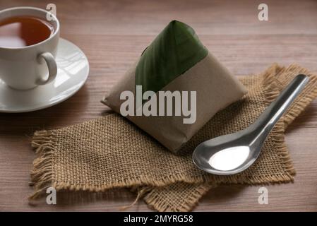 Nasi Lemak , ein beliebtes malaysisches Frühstück, serviert mit einer Tasse Tee. Stockfoto