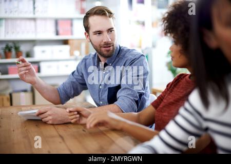 Seine Ideen zum Ausdruck bringen. Ein gutaussehender junger Geschäftsmann, der seine Ideen in einem Meeting teilt. Stockfoto