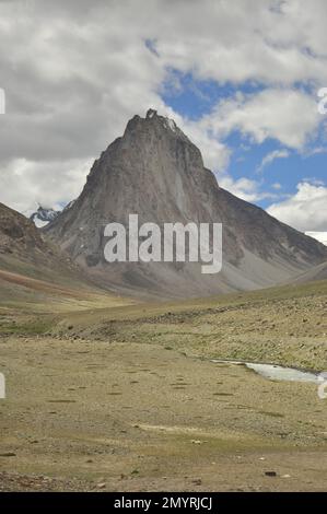 Ein schöner heiliger Berg Gumbok Rangan (Gonbo Rangjon) mit fließendem Kargyak Fluss in der Darcha-Padum Straße, Lungnak Tal, Zanskar, Ladakh, INDIEN. Stockfoto