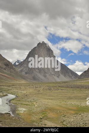 Ein schöner heiliger Berg Gumbok Rangan (Gonbo Rangjon) mit fließendem Kargyak Fluss in der Darcha-Padum Straße, Lungnak Tal, Zanskar, Ladakh, INDIEN. Stockfoto