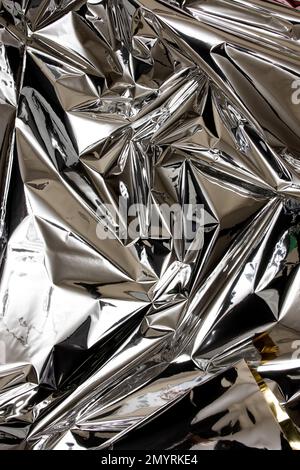 Nahaufnahme aus glänzender Silberfolie. Abstrakter Hintergrund, glänzende Oberfläche Stockfoto