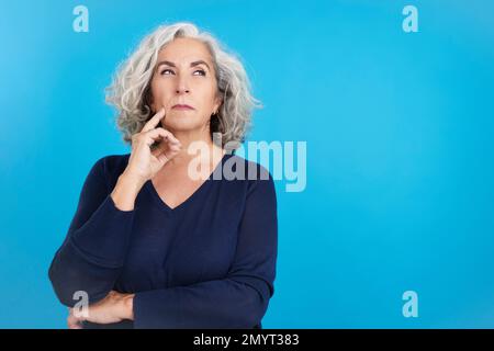 Reife Frau, die mit Bedacht aufblickt Stockfoto