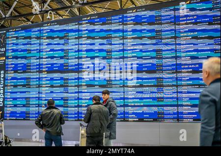 Frankfurt, Deutschland - 4. Februar 2023: Flugplantafel. Reisende, die vor dem Flugplan am internationalen Flughafen stehen. Schließen Stockfoto