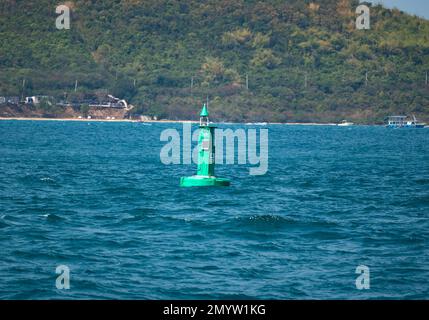 Marineblaue Boje im Fairway. Navigationsschilder. Schiff zum Hafen eskortieren. Schwimmende grüne Navigationsboje auf blauem Meer. Seesignalboje. Navigation Stockfoto