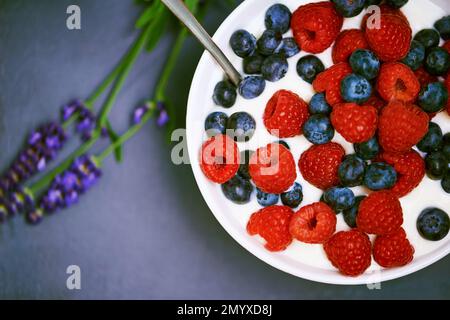 Frisch gepflückte Süßigkeiten aus dem Garten. Ein Schüssel Beeren in Joghurt. Stockfoto