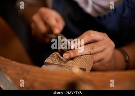 Ich arbeite an den Details. Ein Künstler, der etwas aus Holz kreiert. Stockfoto