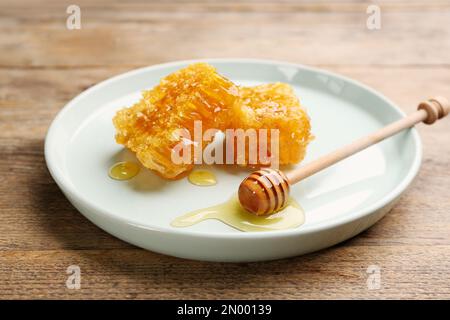 Schmackhafter Honig und Kämme auf Holztisch Stockfoto