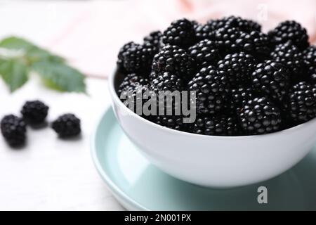 Frische reife Brombeeren in Schüssel auf weißem Tisch, Nahaufnahme Stockfoto