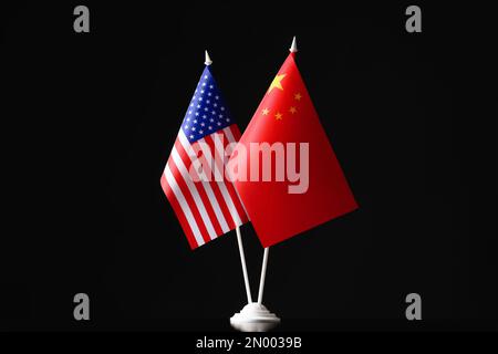Flaggen der USA und Chinas vor schwarzem Hintergrund. Internationale Beziehungen Stockfoto