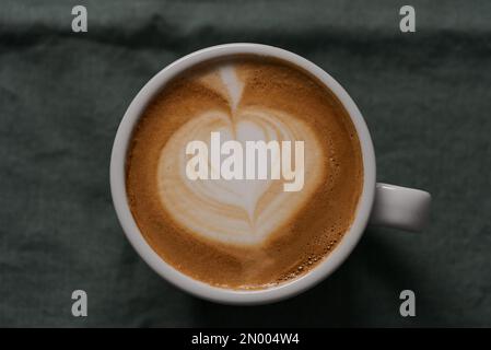 Top-Down-Aufnahme von flachem weißem Kaffee in weißer Tasse, geringer Fokus Stockfoto