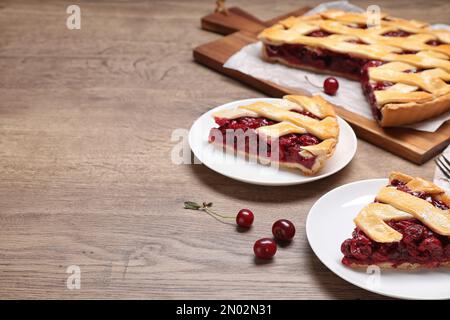 Scheiben köstlicher frischer Kirschkuchen, serviert auf einem Holztisch. Platz für Text Stockfoto