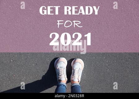 Text bereit für 2021 auf Asphalt vor der Frau, Draufsicht Stockfoto