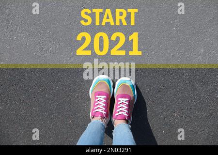 Text Start 2021 auf Asphalt vor der Frau, Draufsicht Stockfoto