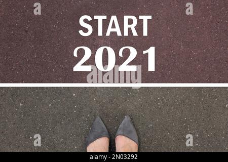 Text Start 2021 auf Asphalt vor der Frau, Draufsicht Stockfoto