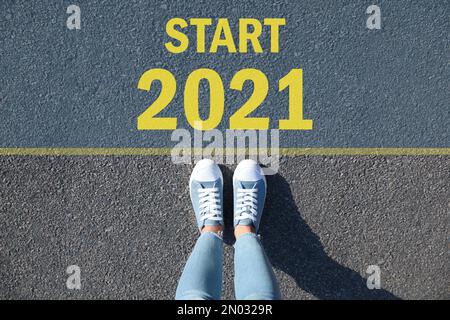 Text Start 2021 auf Asphalt vor der Frau, Draufsicht Stockfoto