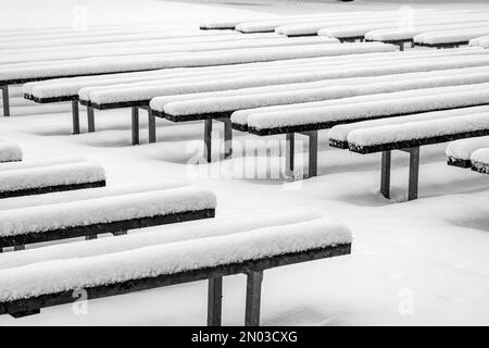 Verschneite Stufen am Ufer des Sees, interessante Muster, nebiger und körniger Hintergrund von herabfallendem Schnee, Winter Stockfoto