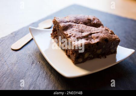 Ein Brownie ist ein kleiner Schokoladenkuchen, typisch für die Gastronomie der Vereinigten Staaten. Er ist nach seiner dunkelbraunen Farbe benannt, oder in Englisch braun. Stockfoto