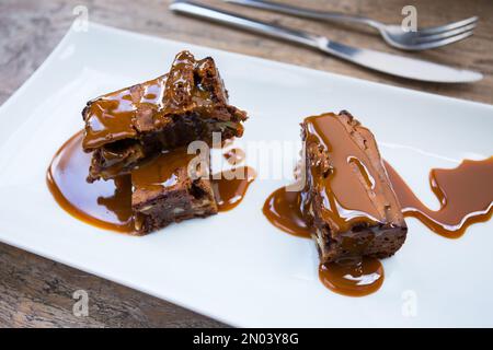 Ein Brownie ist ein kleiner Schokoladenkuchen, typisch für die Gastronomie der Vereinigten Staaten. Er ist nach seiner dunkelbraunen Farbe benannt, oder in Englisch braun. Stockfoto