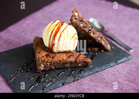 Ein Brownie ist ein kleiner Schokoladenkuchen, typisch für die Gastronomie der Vereinigten Staaten. Er ist nach seiner dunkelbraunen Farbe benannt, oder in Englisch braun. Stockfoto