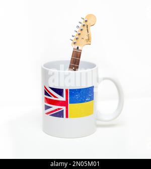 Unterstützung für die Ukraine. Musiker unterstützen ukrainische Hilfe. Gitarre und Kaffeetasse. Ukraine Relief, DEZ, Rotes Kreuz Fonds.Ukraine Flagge, Union Jack Stockfoto