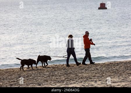 Sandbanks, Poole, Dorset, Großbritannien. 5. Februar 2023 Wetter im Vereinigten Königreich: Sonnenschein am Sandbanks Beach in Dorset, während Besucher sich zum Sport, zur frischen Luft und zum Sonnenbaden an die Küste begeben. Kredit: Carolyn Jenkins/Alamy Live News Stockfoto