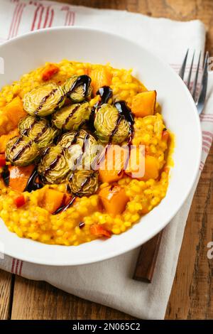 Squash Risotto mit geröstetem Rosenkohl und Balsamico-Reduktionsmittel Stockfoto