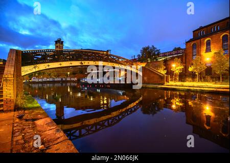 Reflexion einer Fußgängerbrücke im Rochdale-Kanal durch Manchester City, Großbritannien Stockfoto