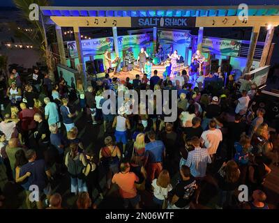 Babylon, New York, USA - 20. August 2021: Die Leute stehen und tanzen zu einer Band, die nachts im Salt Shack am Strand von Long Island Musik spielt. Stockfoto