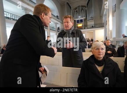 05. Februar 2023, Schleswig-Holstein, Neumünster: Daniel Günther (l, CDU), Ministerpräsident von Schleswig-Holstein, begrüßt Richard Lutz, CEO der Deutschen Bahn AG, vor der Bestattung der Opfer des Messeranschlags auf einem Regionalzug von Kiel nach Hamburg. Anna-Katharina Schättiger (CDU), Präsidentin der Stadt Neumünster, sitzt auf der rechten Seite. Der Ökumenische Gottesdienst findet in der Vicelinkirche in Neumünster statt. In der Stadt besuchten die Opfer des Verbrechens - ein 17-jähriges Mädchen und ein 19-jähriger junger Mann - eine Berufsschule. Zwei Menschen wurden getötet und fünf verletzt Stockfoto