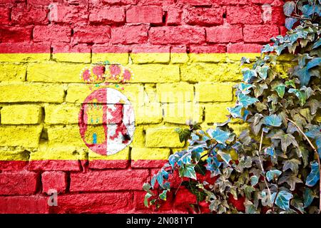 Spanische Grunge-Flagge an der Ziegelwand mit Efeu-Pflanze, Landessymbol-Konzept Stockfoto