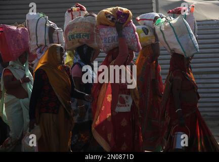 Prayagraj, Indien. Am 5. Februar 2023 kehren indische Anhänger nach ihrem heiligen Bad am Ufer des Ganges anlässlich des einmonatigen jährlichen Magh Mela Festivals in Prayagraj, Indien, zurück. Der Zusammenfluss von drei heiligen Flüssen (Ganga, Yamuna und das mythische Saraswati) Magh Mela findet bei „angam“ statt und zieht Tausende von Hindus an. Während der Magh Mela Hindu-Enthusiasten baden an günstigen Tagen in den Gewässern des Ganges in Prayagraj, Indien. Kredit: Anil Shakya/Alamy Live News Stockfoto