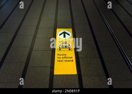 Wegbeschreibung zum offiziellen Taxistand auf dem Gehweg des internationalen Flughafens Schiphol, Niederlande Stockfoto