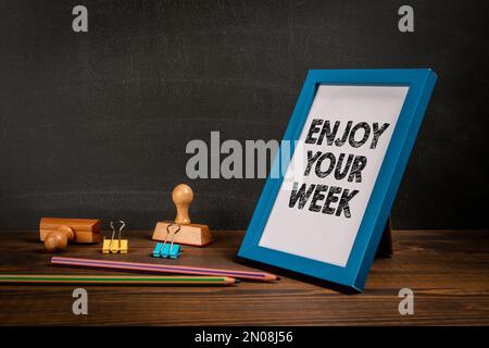 Viel Spaß Bei Der Woche. Schreibtisch aus Holz mit Schreibwaren. Stockfoto