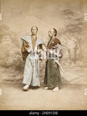 Ein Foto von zwei japanischen Samurai in traditionellen Kostümen, veröffentlicht in „Views & Costumes of Japan“ von Stillfried und Andersen (Yokohama, 1877). Stockfoto