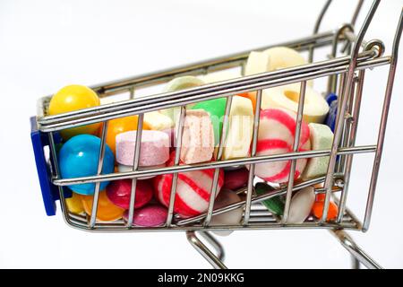 Viele bunte, verschiedene Süßigkeiten in einem kleinen Einkaufswagen. Stockfoto