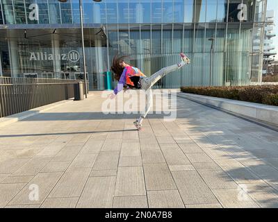 Ein fantastisches Bild eines jungen Mädchens, das in modischer Kleidung tanzt, unter dem CityLife Allianz Tower, Isozaki Tower, CityLife, Mailand, Italien Stockfoto