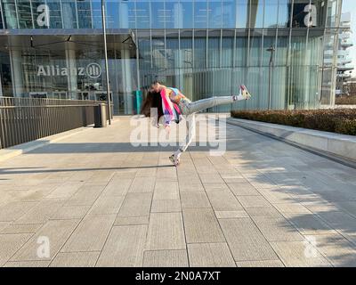 Ein fantastisches Bild eines jungen Mädchens, das in modischer Kleidung tanzt, unter dem CityLife Allianz Tower, Isozaki Tower, CityLife, Mailand, Italien Stockfoto