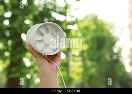 Frau mit tragbarem Ventilator im Freien am sonnigen Sommertag, Schließung. Platz für Text Stockfoto