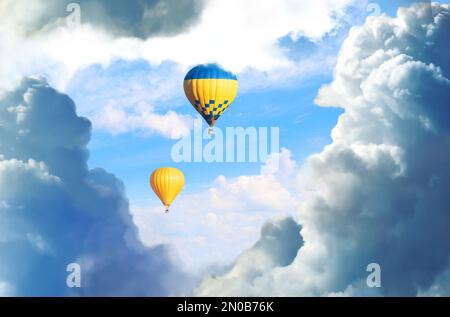 Fantastische Träume. Heißluftballons in blauem Himmel mit flauschigen Wolken Stockfoto